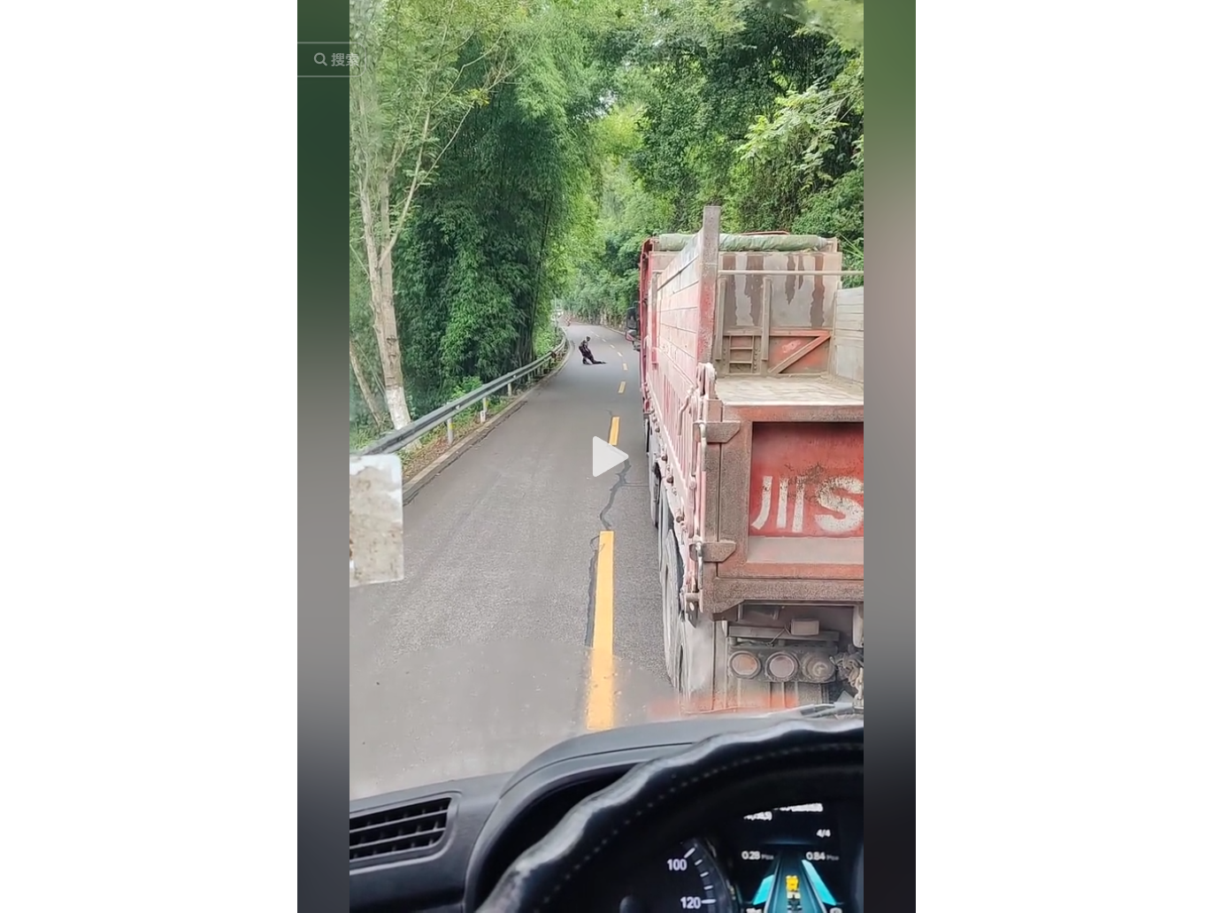 行车记录仪视角,前方红色货车行驶在绿树成荫的山路上,远处一人蹲在路边。