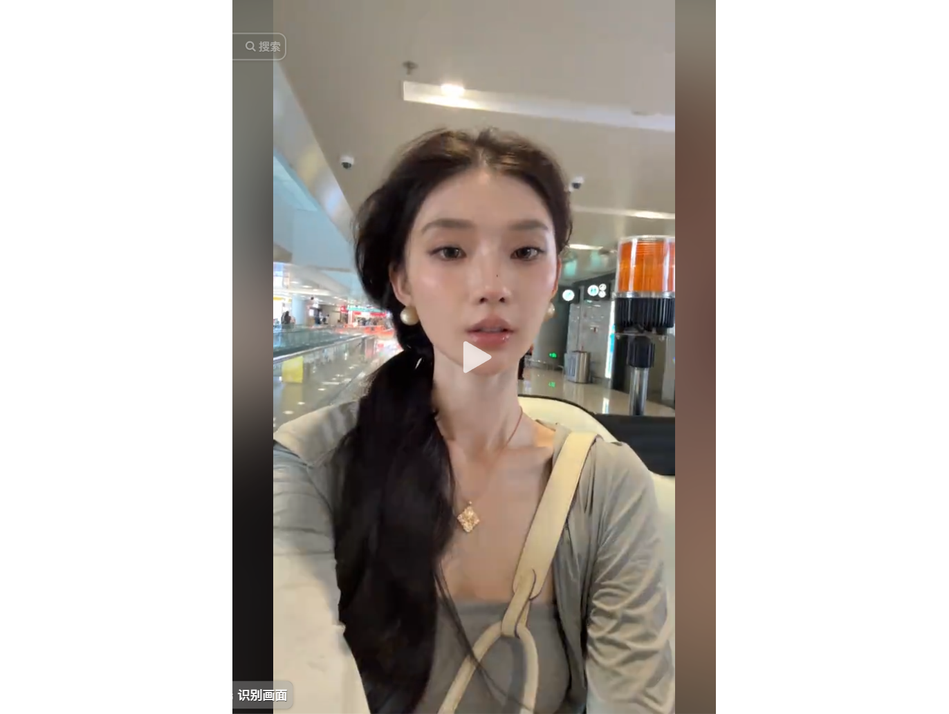 一位年轻女性在商场内自拍,背景有扶梯和店铺。