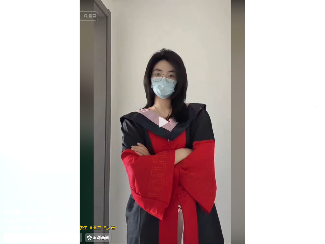 A person wearing a red and black academic gown and