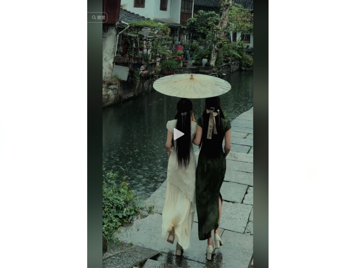 Two women in traditional attire walk along a canal