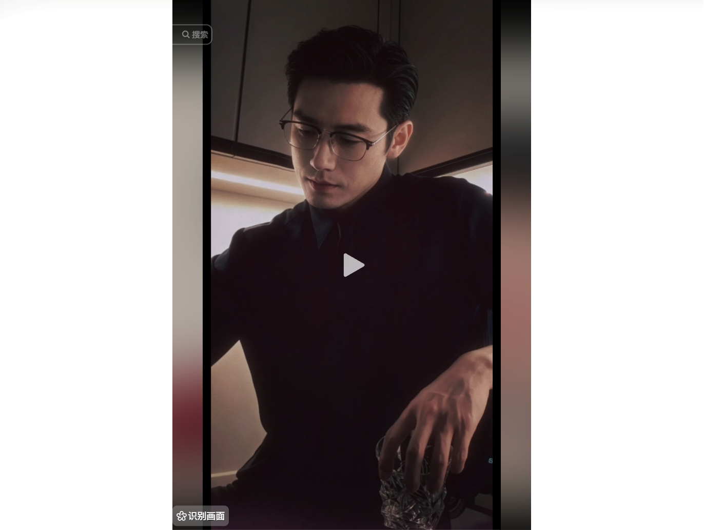 戴眼鏡的男子穿黑色上衣，手拿玻璃杯