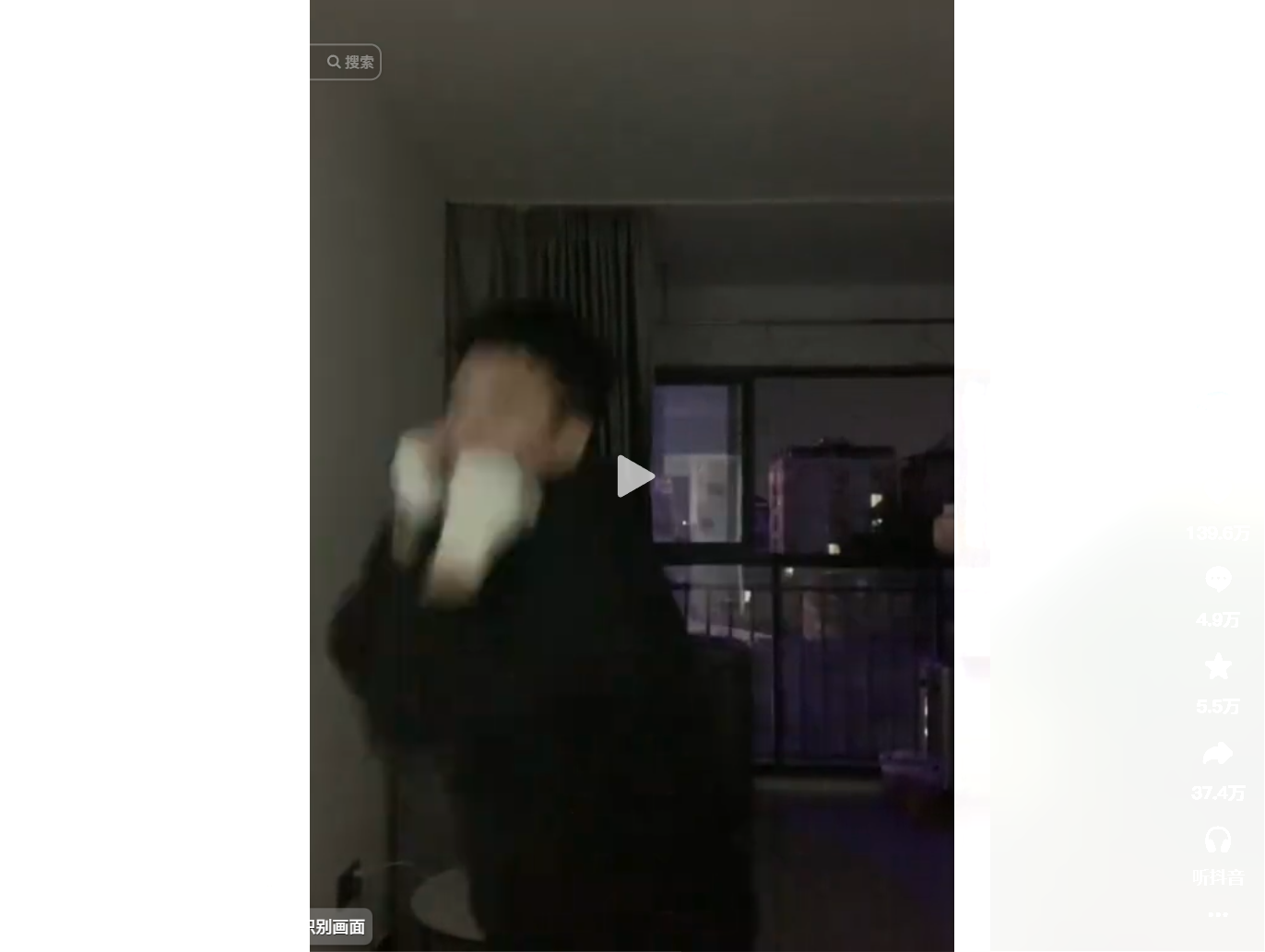 A person in a dark room holding a white object nea
