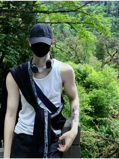 "户外森林里戴帽子口罩的男生 白背心酷帅男生穿搭照片".webp